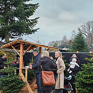 Besucher einer Firmenweihnachtsfeier im Freien mit Adventsmarkt 1