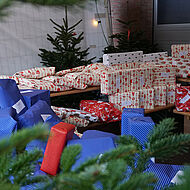 Rote und blaue Weihnachtsgeschenke vor einem Tannenbaum